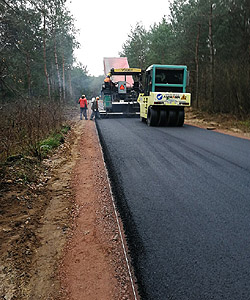 Podgląd utwardzania walcem ostatniej warstwy asfaltu pod nowoą drogę w miejscowości Ryczywół